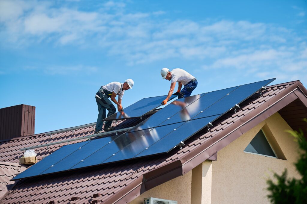 workers,building,solar,panel,system,on,rooftop,of,house.,two